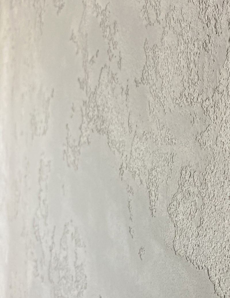 Close-up of a textured stone-effect wall finish with raised, rough-hewn edges